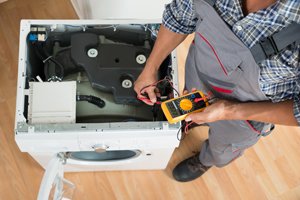 Appliance repair technician from STAATS Service Today fixing a washing machine in Creve Coeur, IL